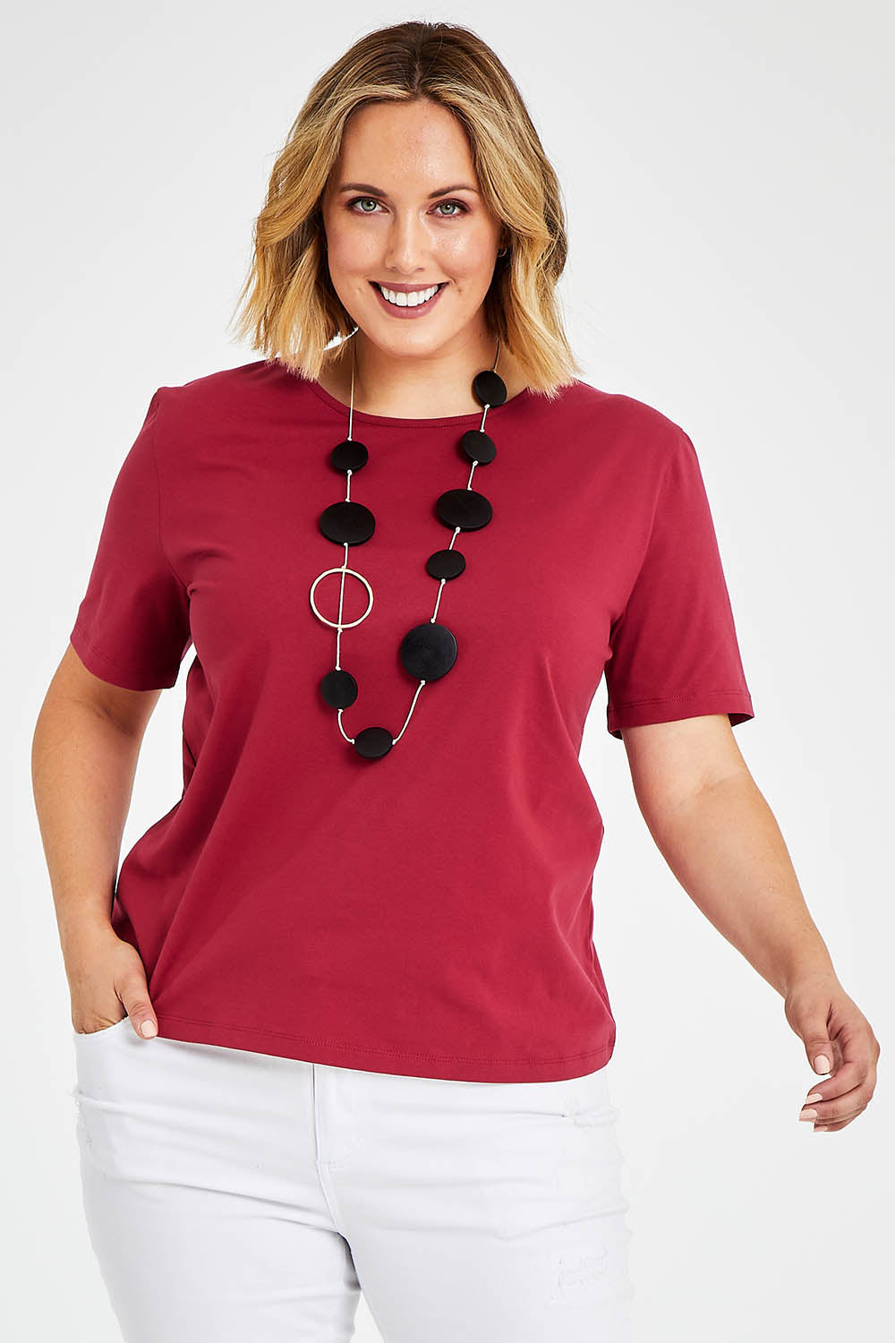 Model Jess wearing size 14 of The Keepers Tee in colour Rose (Pink), from the front, cropped image