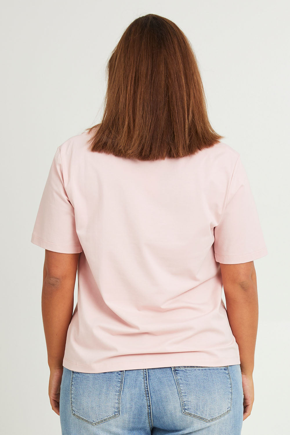 Model Monique wearing size 14 of The Keepers Tee in colour Softpink (Pink), from the back
