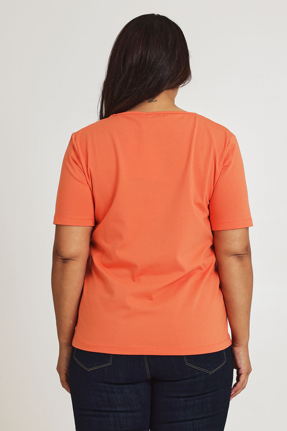 Model Ashleigh wearing size 16 of The Keepers Tee in colour Sunset, from the back