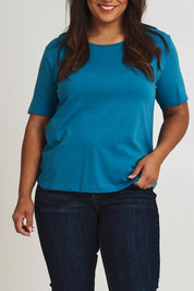 Model Ashleigh wearing size 16 of The Keepers Tee in colour Turquoise (Blue), from the front, cropped image