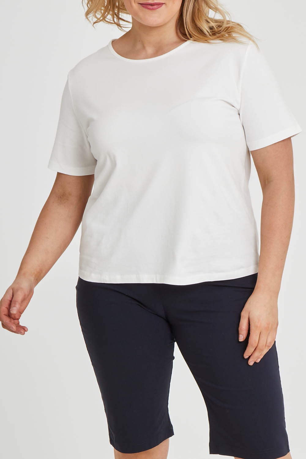 Model Keeara wearing size 16 of The Keepers Tee in colour White (White), from the front, cropped image