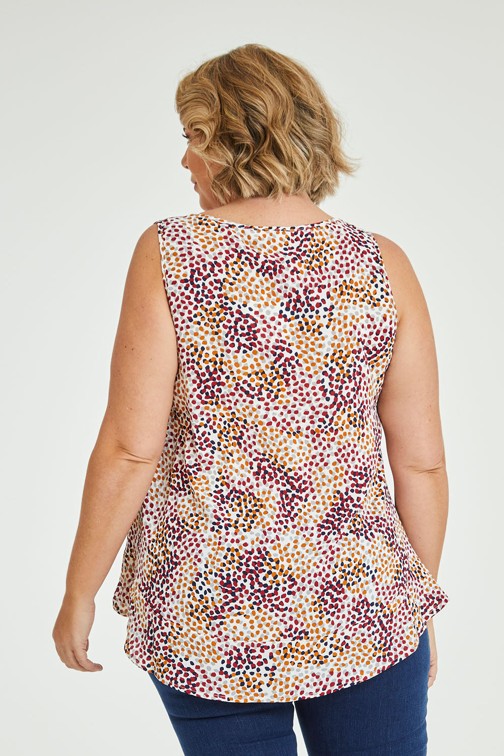 Model Fiona wearing size 16 of The Woven Swing Tank in colour Multispot (White), from the back