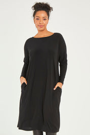 Model Noli wearing size 14 of The Recycled Long Sleeve Everyday Dress in colour Black (Black), from the front, cropped image
