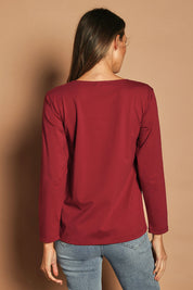 Model Madeline wearing size 10 of The Keepers Long Sleeve Tee in colour Shiraz (Red), from the back