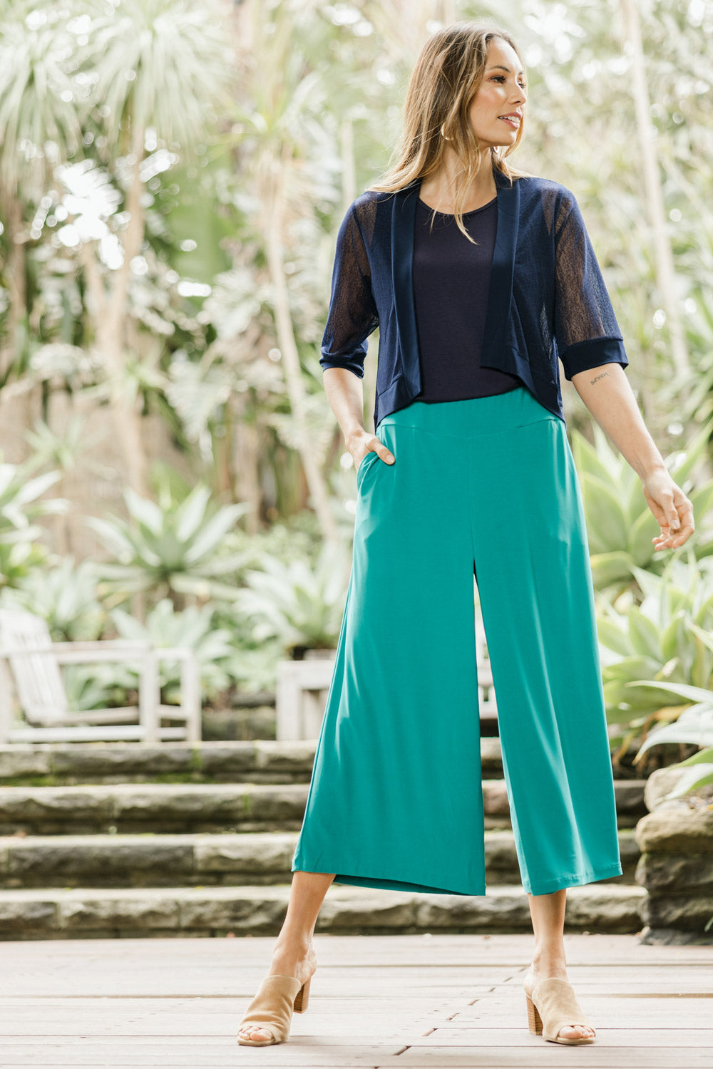 Model Amanda wearing size 10 of The Recycled Pleated Culottes in colour Emerald (Green), from the front, showing the whole outfit
