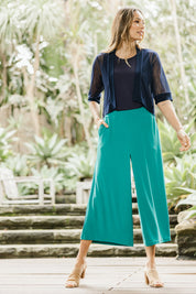 Model Amanda wearing size 10 of The Recycled Pleated Culottes in colour Emerald (Green), from the front, showing the whole outfit