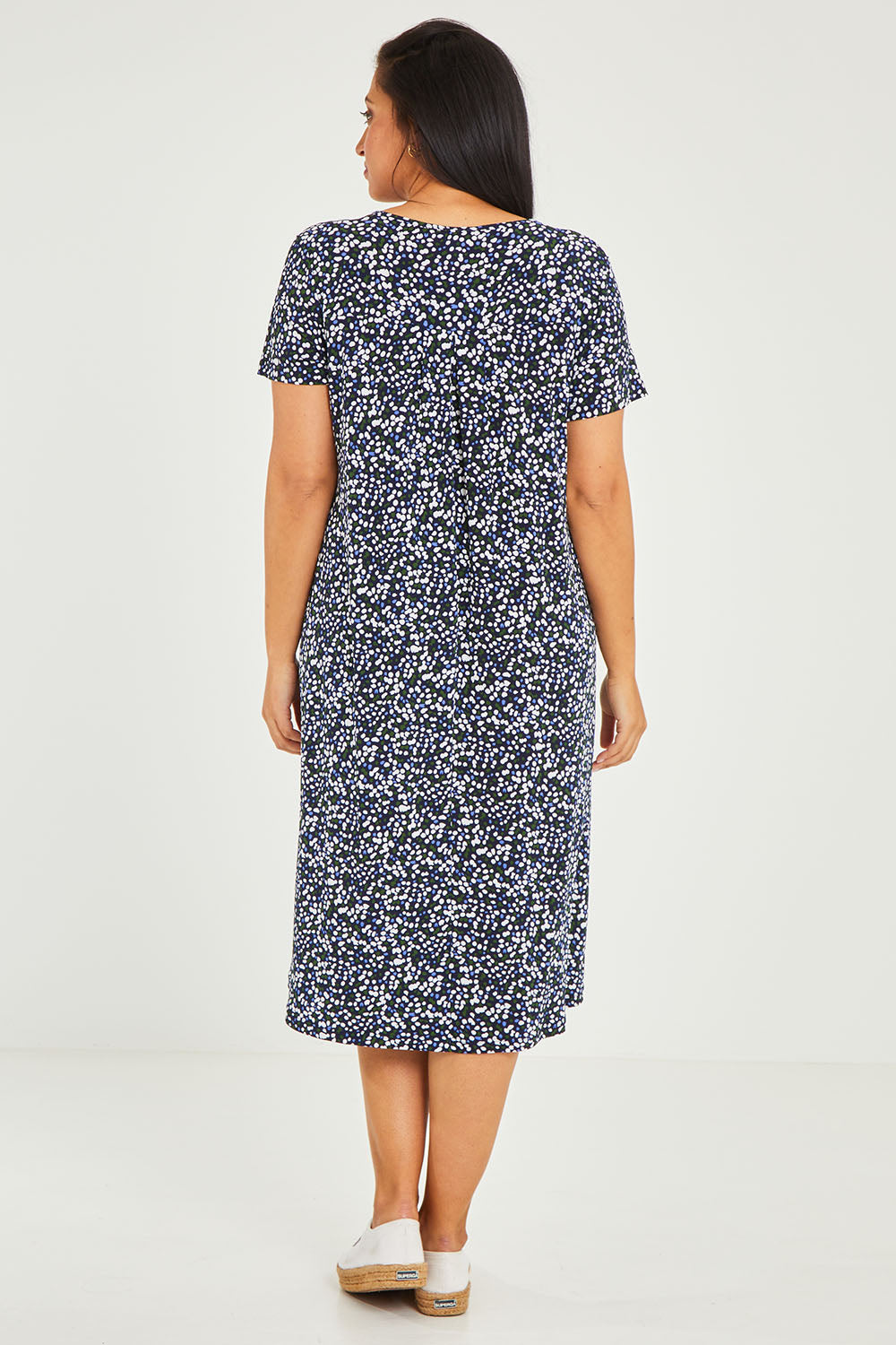 Model Terri-Leigh wearing size 14 of The Print Back Pleat Tee Dress in colour Multispot (Blue), from the back