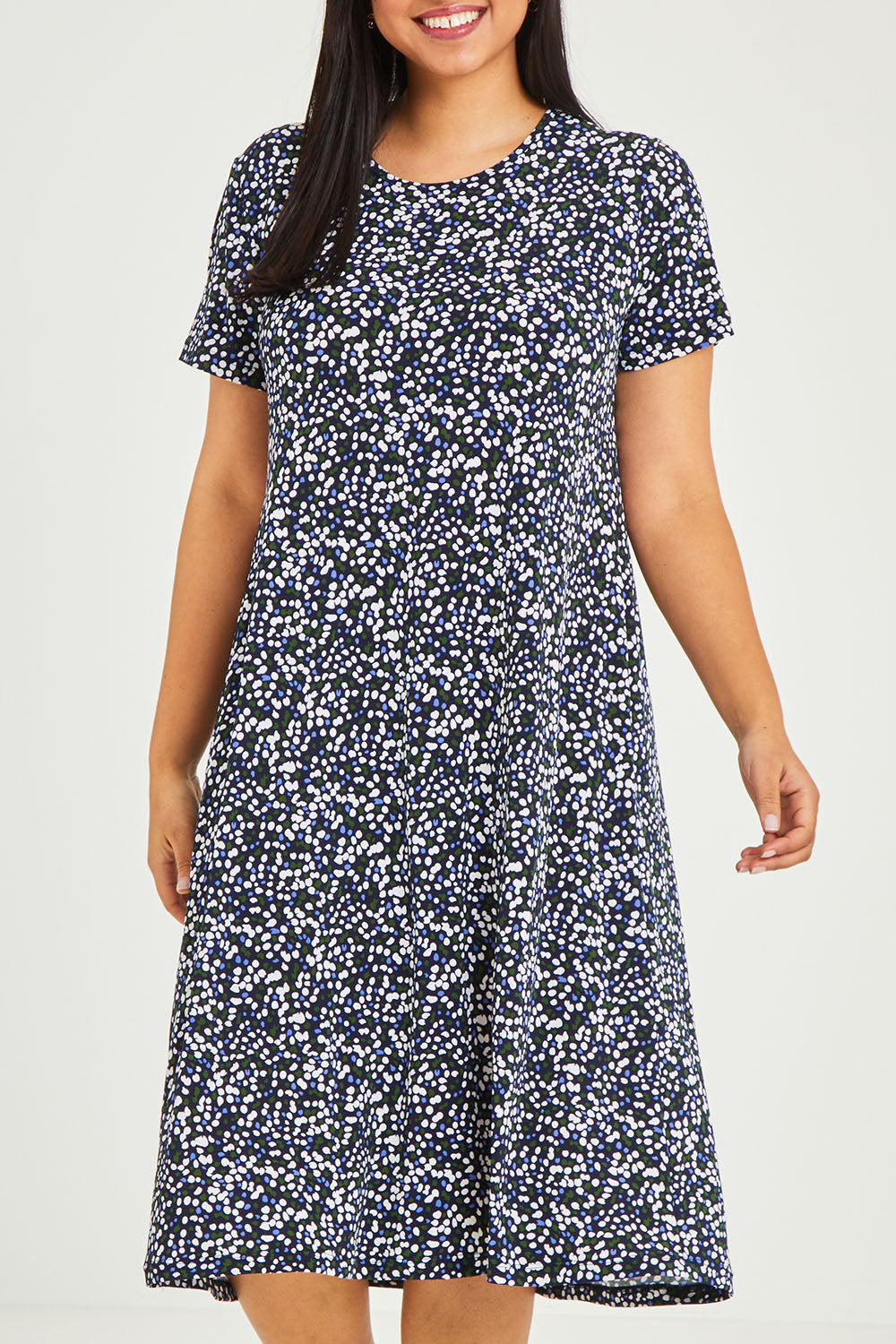 Model Terri-Leigh wearing size 14 of The Print Back Pleat Tee Dress in colour Multispot (Blue), from the front, cropped image