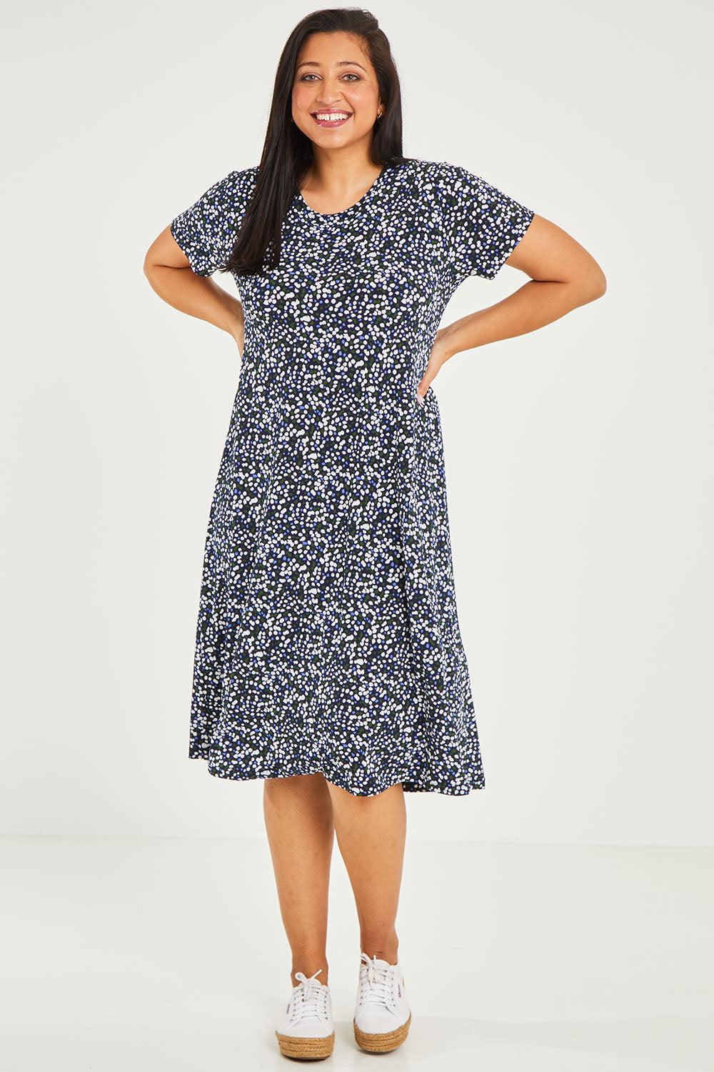 Model Terri-Leigh wearing size 14 of The Print Back Pleat Tee Dress in colour Multispot (Blue), from the front, showing the whole outfit