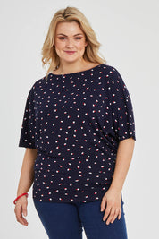 Model Keeara wearing size 16 of The Printed Wide Basque Top in colour Navyspot (Blue), from the front, cropped image