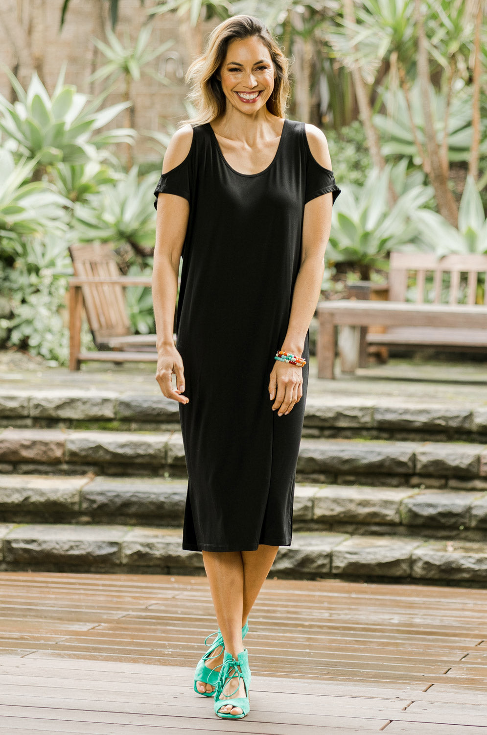 Model Amanda wearing size 10 of The Bamboo Cold Shoulder Dress in colour Black (Black), from the front, showing the whole outfit