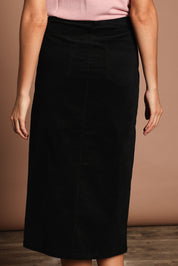 Model Madeline wearing size 10 of The 5 Pocket Cord Midi Skirt in colour Black (Black), from the back