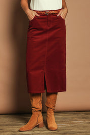 Model Madeline wearing size 10 of The 5 Pocket Cord Midi Skirt in colour Cherryred (Red), from the front, cropped image
