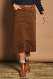 Model Madeline wearing size 10 of The 5 Pocket Cord Midi Skirt in colour Malt, from the front, cropped image