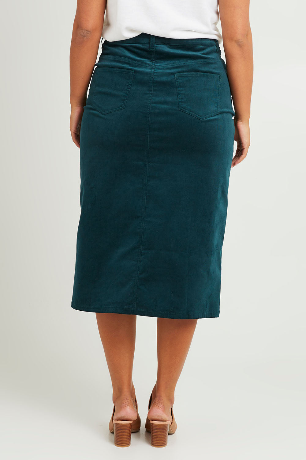 Model Monique wearing size 14 of The 5 Pocket Cord Midi Skirt in colour Petrol (Blue), from the back
