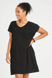 Model Noli wearing size 14 of The Luxe Cotton Tee Dress in colour Black (Black), from the front, cropped image