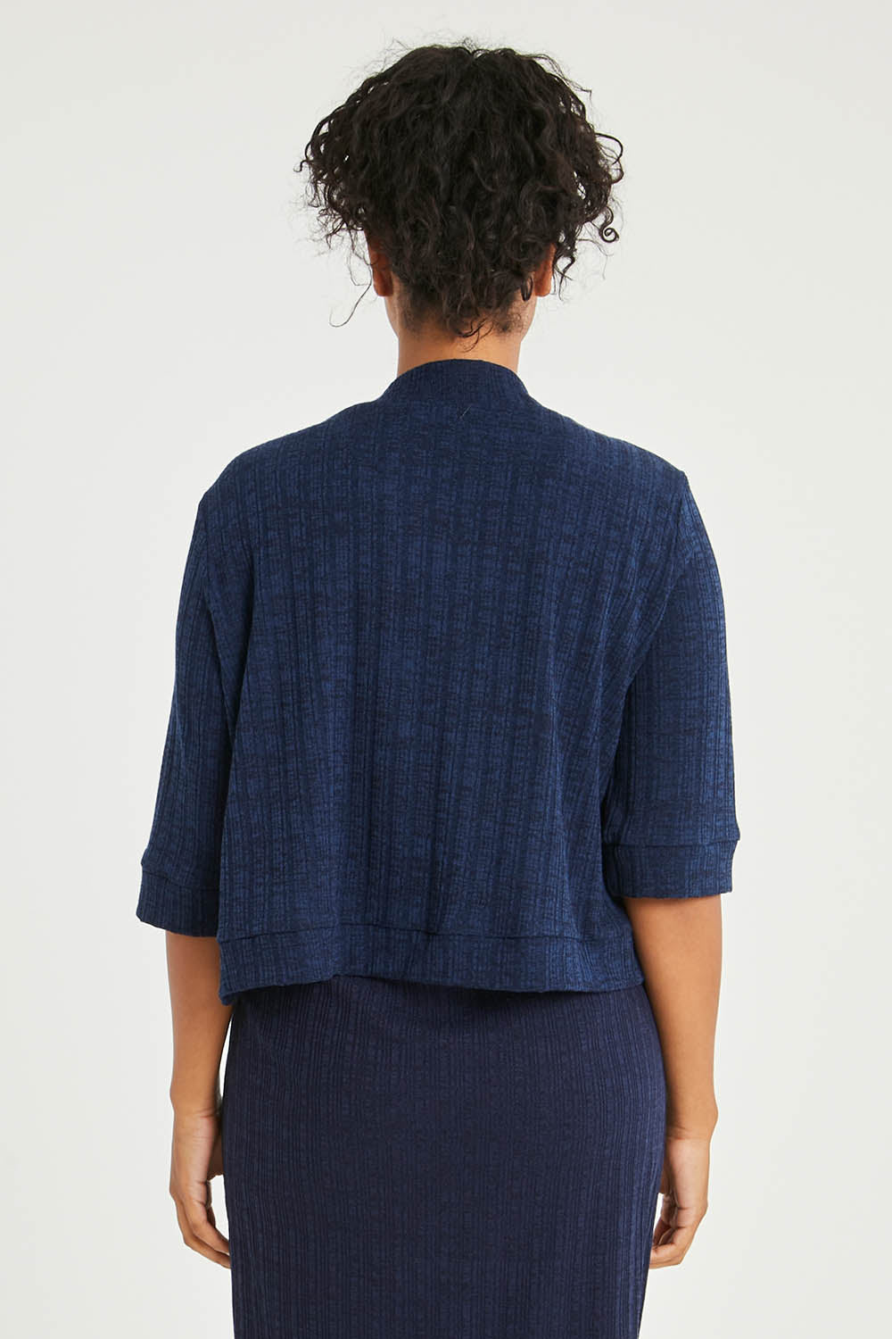 Model Noli wearing size 14 of The Lightweight Knit Shrug in colour Navy (Blue), from the back