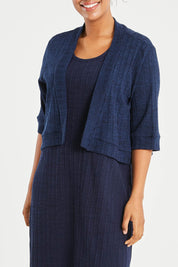 Model Noli wearing size 14 of The Lightweight Knit Shrug in colour Navy (Blue), from the front, cropped image