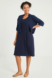 Model Noli wearing size 14 of The Lightweight Knit Shrug in colour Navy (Blue), from the front, showing the whole outfit