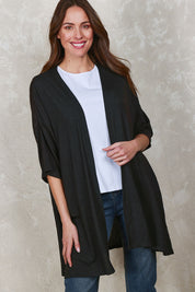 Model Madeline wearing size 10 of The Perfect Summer Knit Cardi in colour Black (Black), from the front, showing the whole outfit