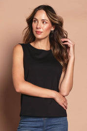 Model Madeline wearing size 10 of The Keepers Classic Tank in colour Black (Black), from the front, cropped image