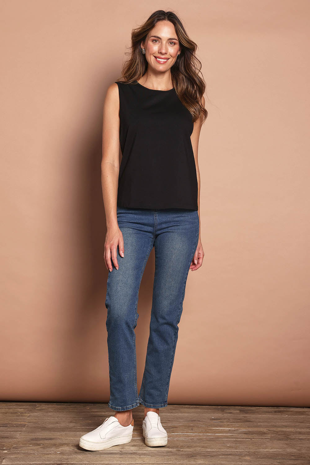 Model Madeline wearing size 10 of The Keepers Classic Tank in colour Black (Black), from the front, showing the whole outfit
