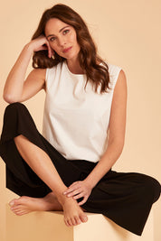 Model Madeline wearing size 10 of The Keepers Classic Tank in colour White (White), from the front, cropped image