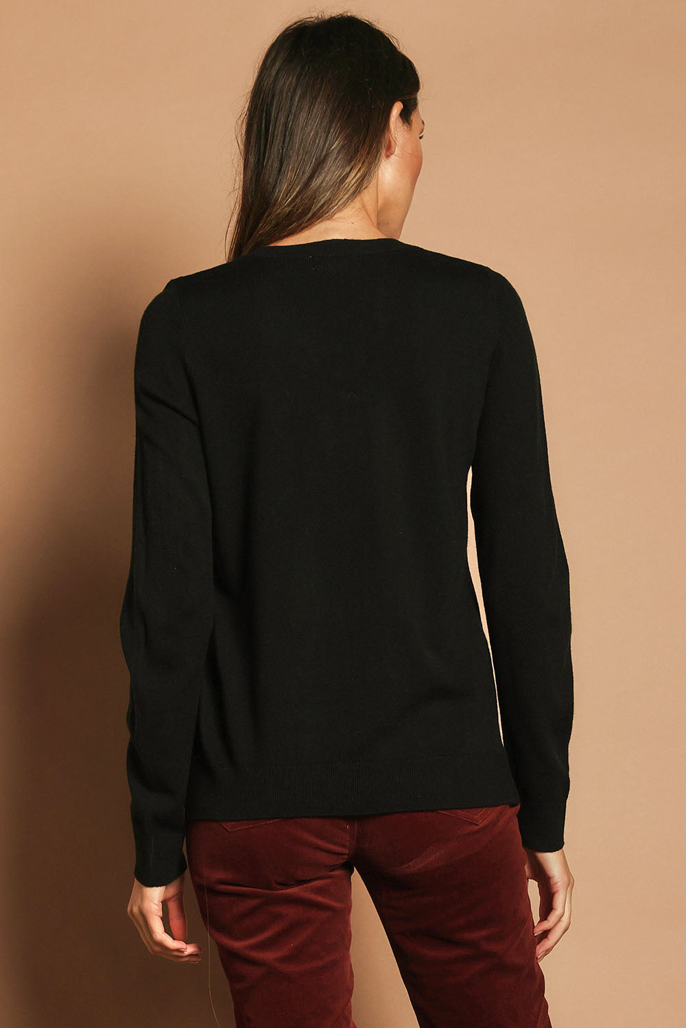 Model Madeline wearing size S of The Keepers Soft V Neck Jumper in colour Black (Black), from the back