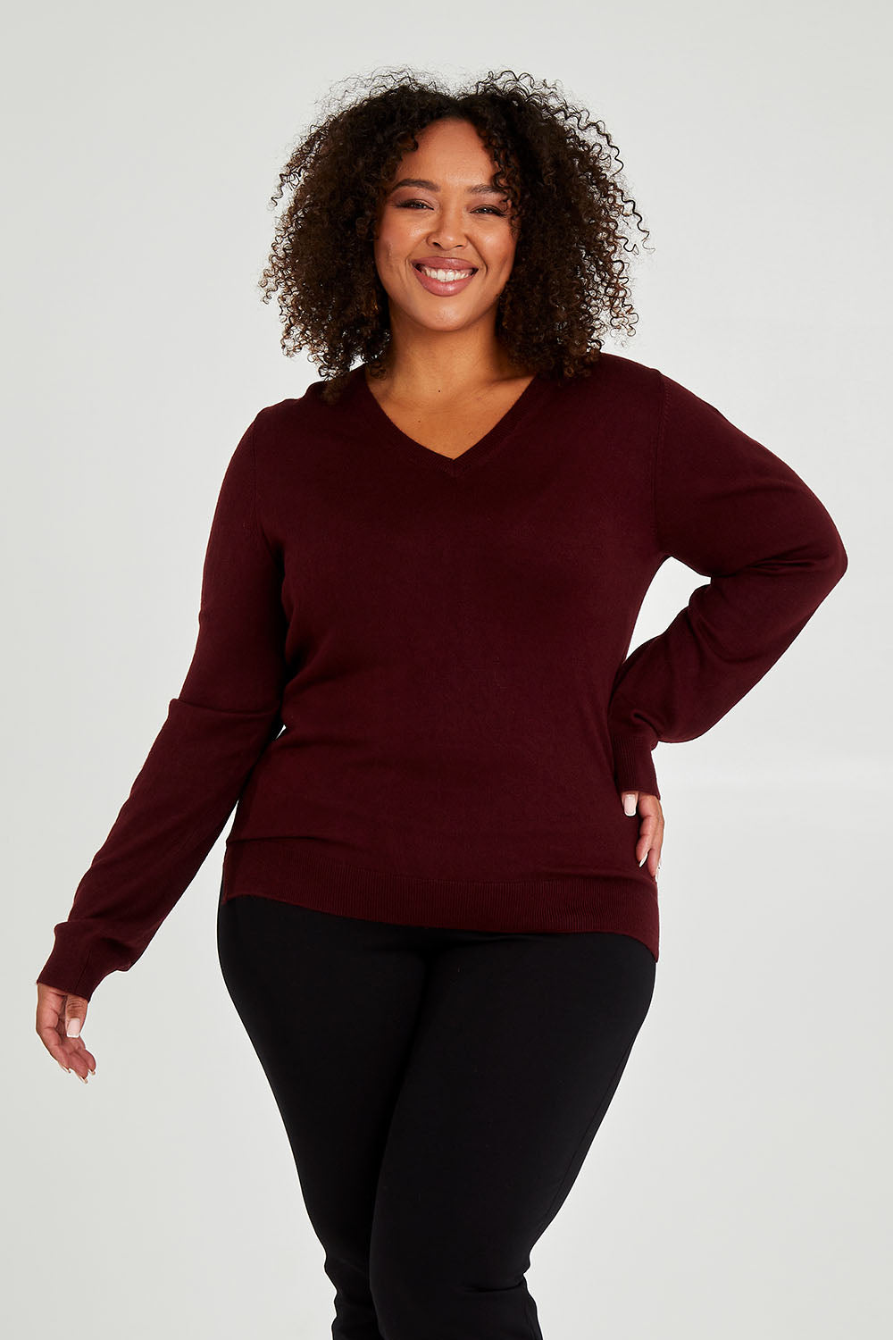 Model Alexis wearing size XL of The Keepers Soft V Neck Jumper in colour Burgundy (Purple), from the front, cropped image