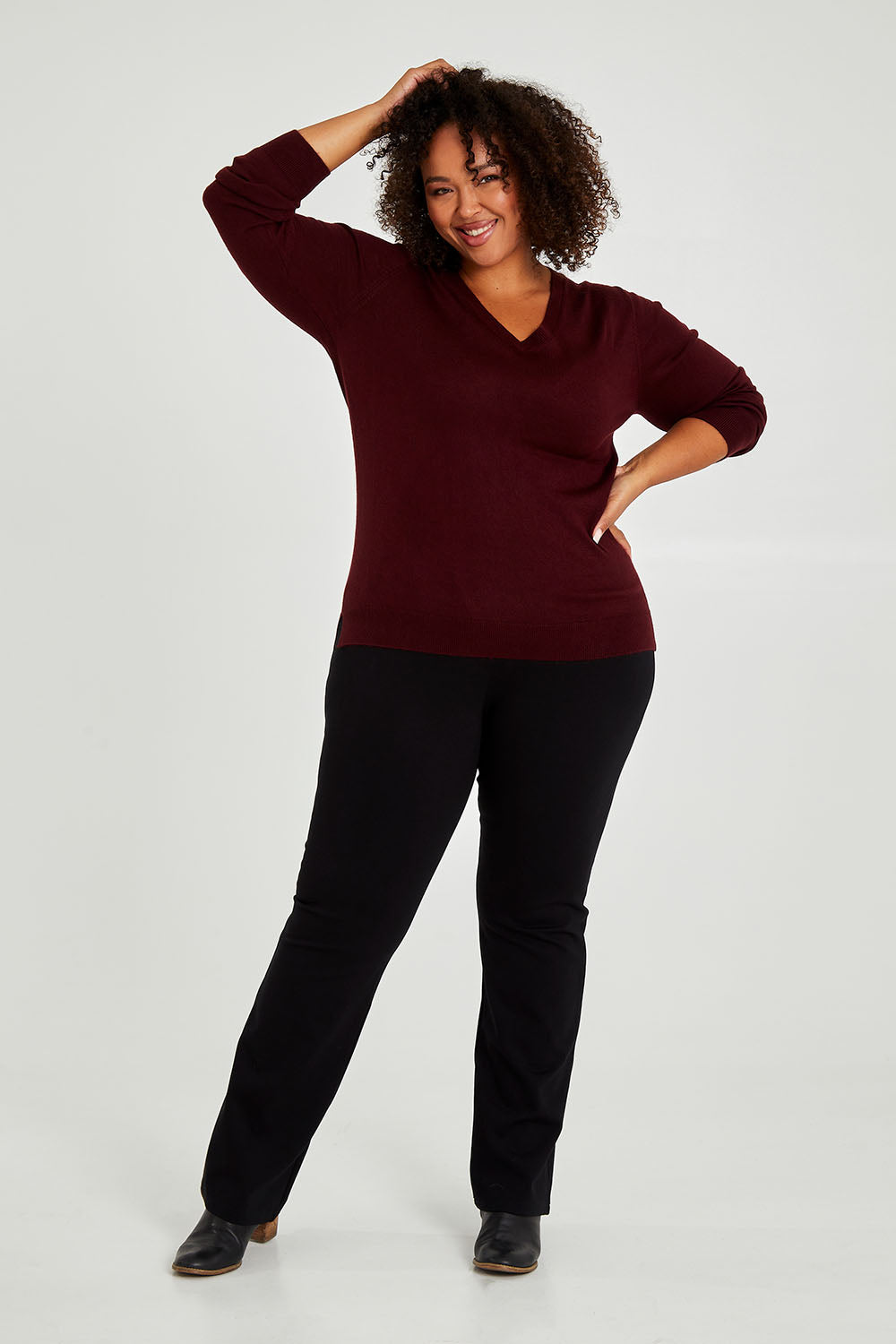 Model Alexis wearing size XL of The Keepers Soft V Neck Jumper in colour Burgundy (Purple), from the front, showing the whole outfit
