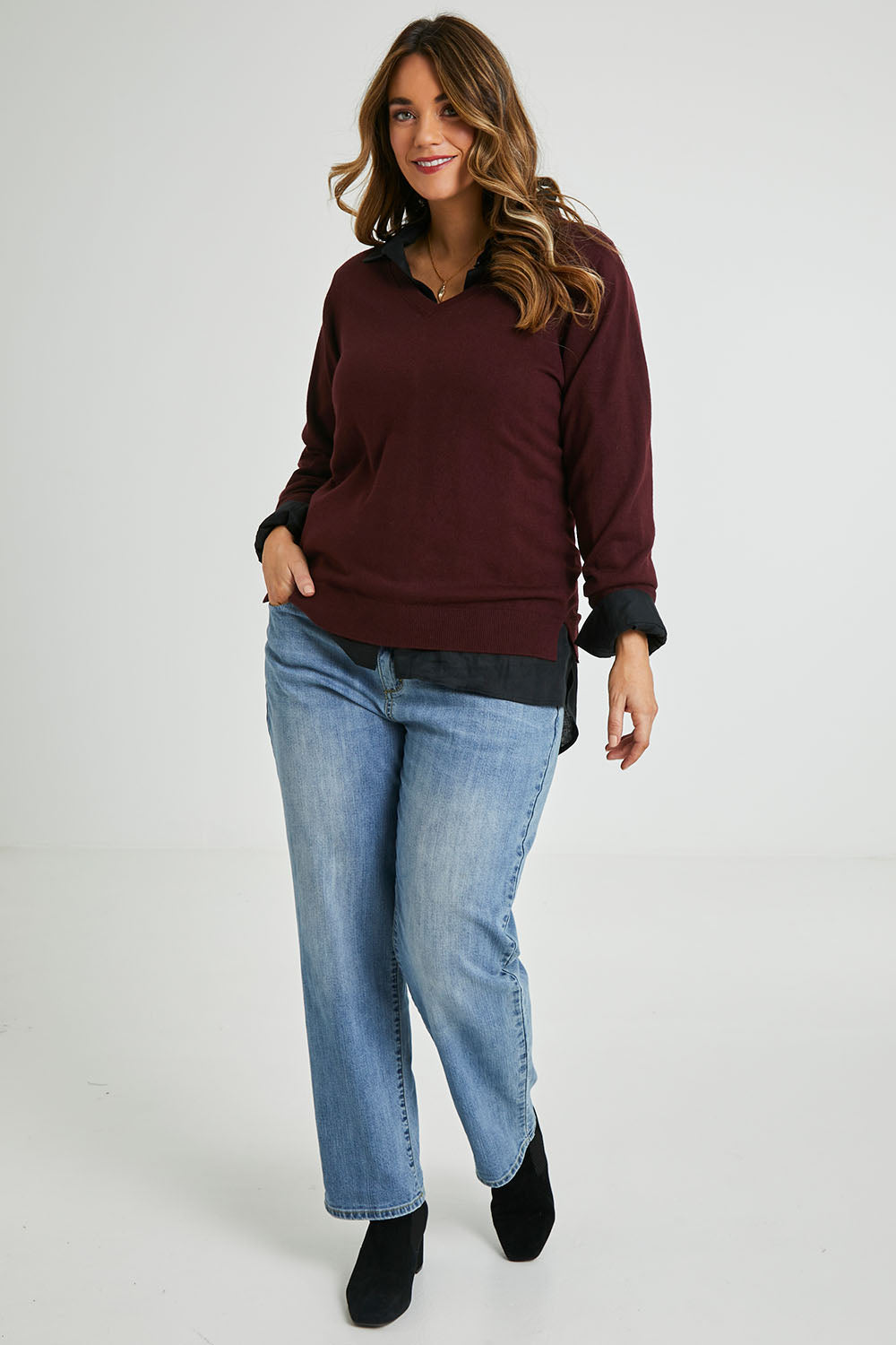 Model Laura wearing size L of The Keepers Soft V Neck Jumper in colour Burgundy (Purple), from the front, showing the whole outfit