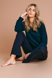 Model Alice wearing size S of The Keepers Soft V Neck Jumper in colour Darkpetrol (Blue), from the front, showing the whole outfit