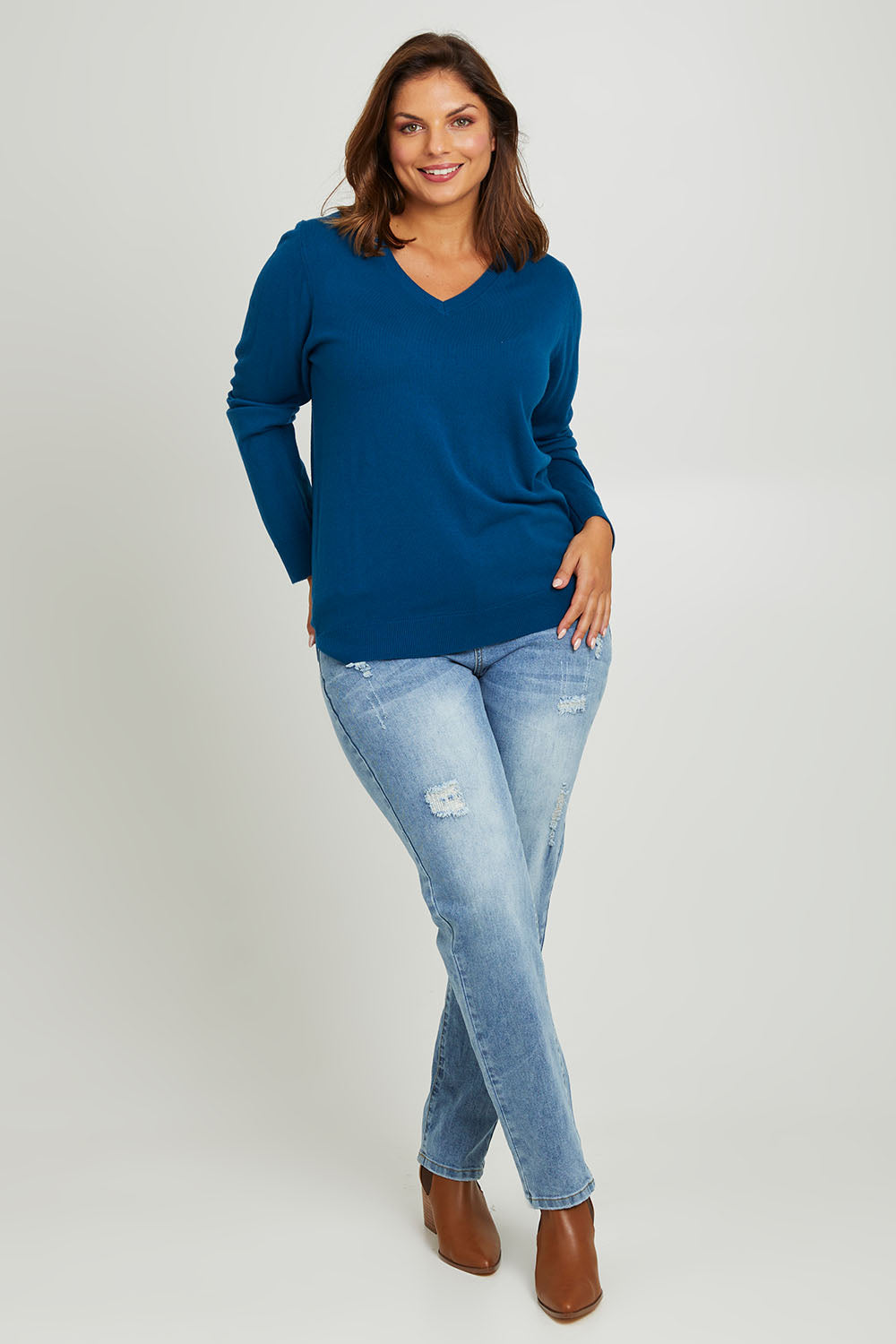 Model Monique wearing size L of The Keepers Soft V Neck Jumper in colour Petrol (Blue), from the front, showing the whole outfit