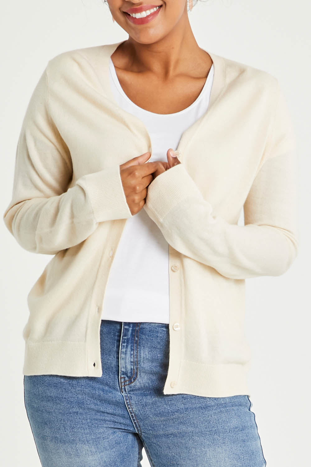 Model Noli wearing size L of The Keepers Soft Button Up Cardigan in colour Ivory (White), from the front, cropped image