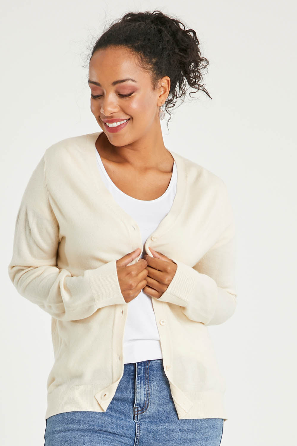 Model Noli wearing size L of The Keepers Soft Button Up Cardigan in colour Ivory (White), from the front, cropped image