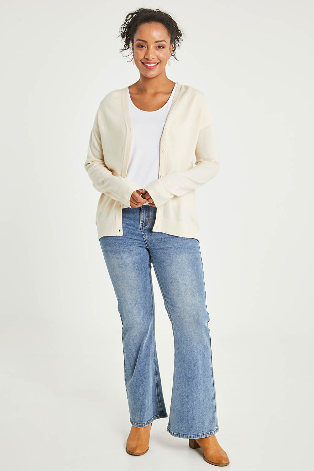 Model Noli wearing size L of The Keepers Soft Button Up Cardigan in colour Ivory (White), from the front, showing the whole outfit
