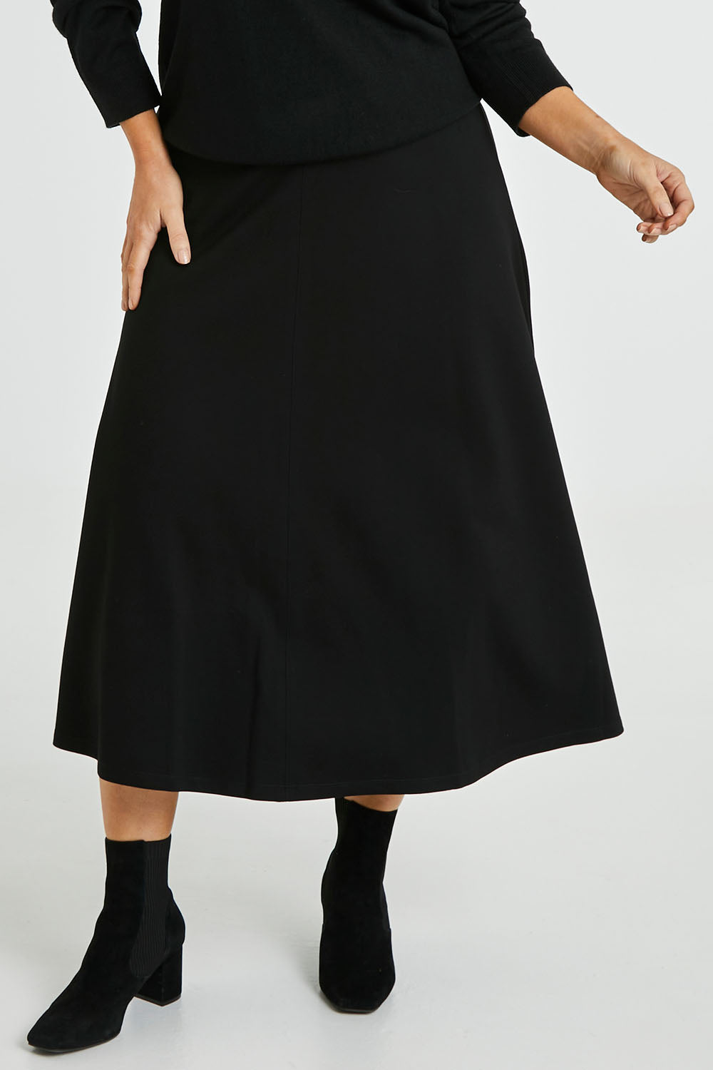 Model Laura wearing size 14 of The Fit And Flare Ponte Skirt in colour Black (Black), from the front, cropped image