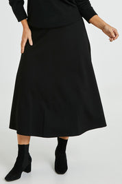 Model Laura wearing size 14 of The Fit And Flare Ponte Skirt in colour Black (Black), from the front, cropped image