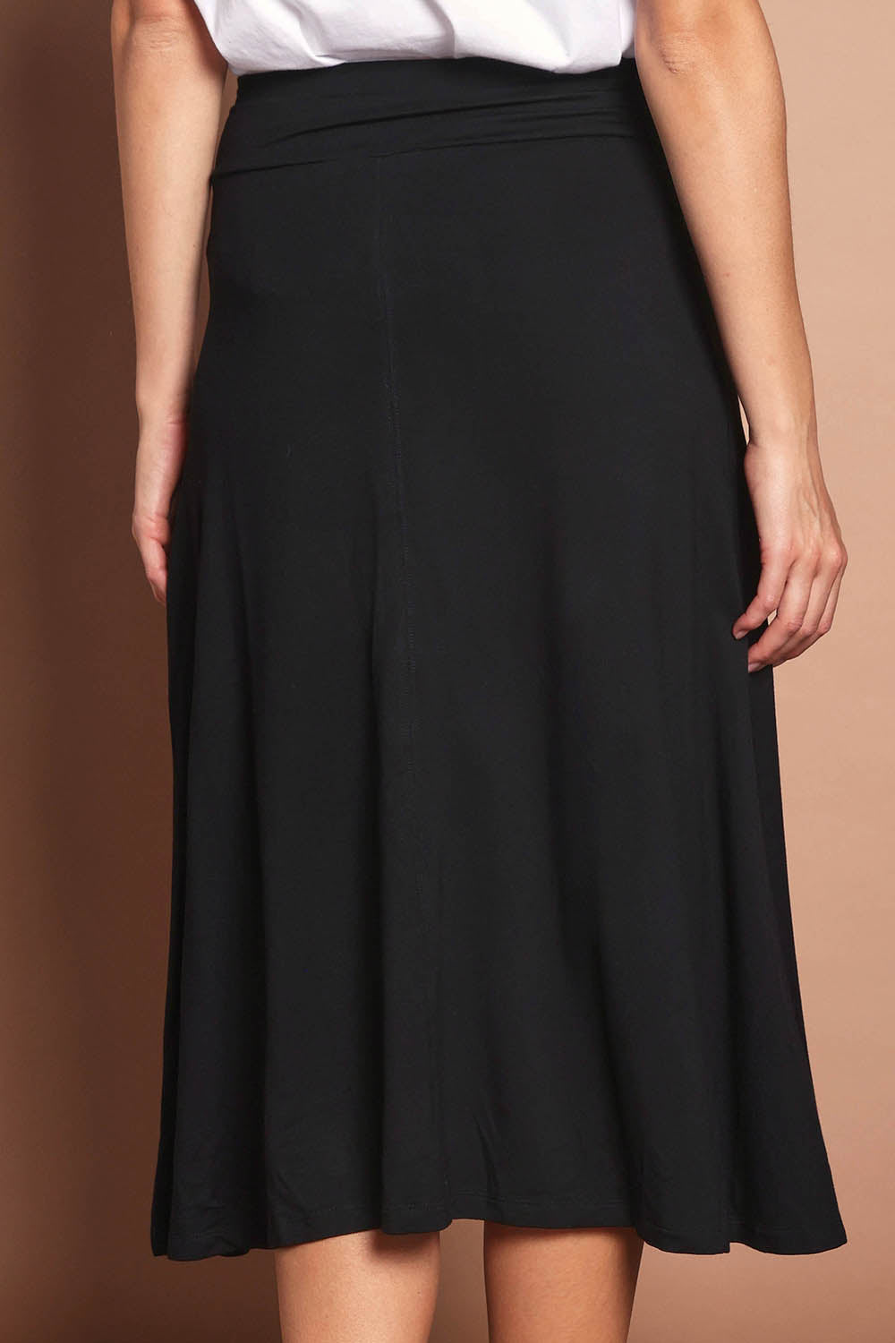 Model Madeline wearing size 10 of The Fit And Flare Ponte Skirt in colour Black (Black), from the back