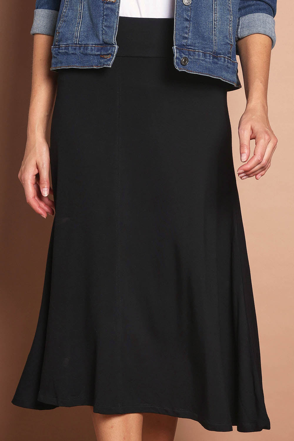 Model Madeline wearing size 10 of The Fit And Flare Ponte Skirt in colour Black (Black), from the front, cropped image