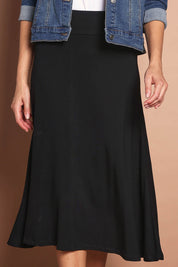 Model Madeline wearing size 10 of The Fit And Flare Ponte Skirt in colour Black (Black), from the front, cropped image