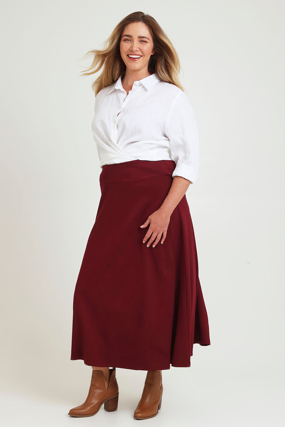 Model Chanel wearing size 16 of The Fit And Flare Ponte Skirt in colour Cognac (Red), from the front, showing the whole outfit