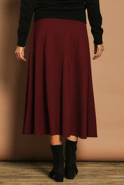 Model Madeline wearing size 10 of The Fit And Flare Ponte Skirt in colour Cognac (Red), from the back