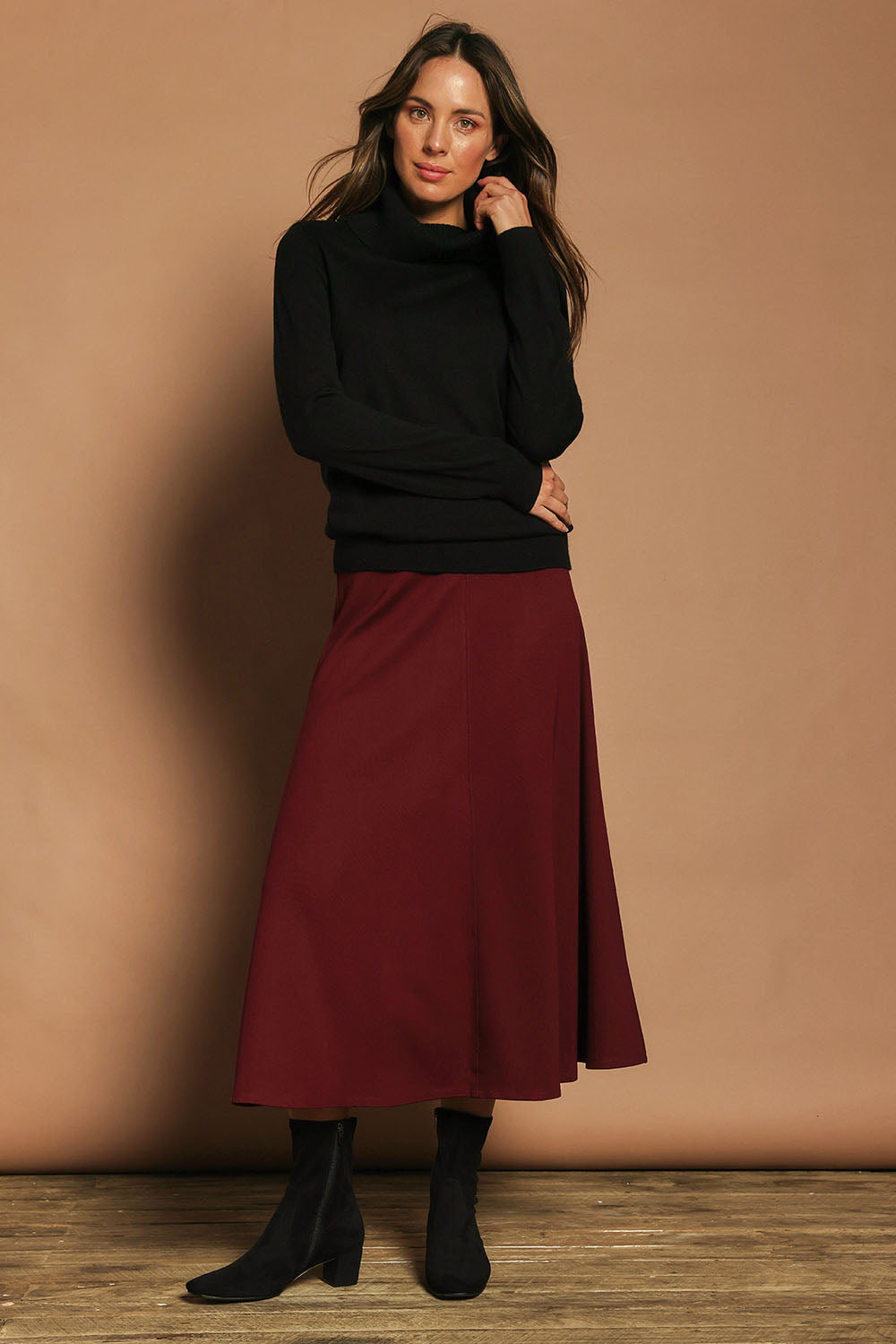 Model Madeline wearing size 10 of The Fit And Flare Ponte Skirt in colour Cognac (Red), from the front, showing the whole outfit