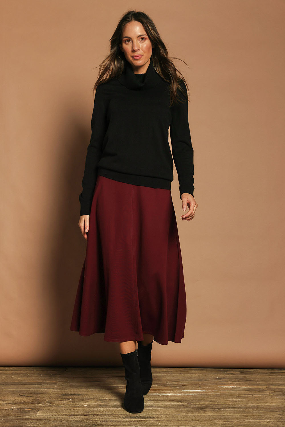 Model Madeline wearing size 10 of The Fit And Flare Ponte Skirt in colour Cognac (Red), from the front, showing the whole outfit