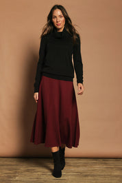 Model Madeline wearing size 10 of The Fit And Flare Ponte Skirt in colour Cognac (Red), from the front, showing the whole outfit