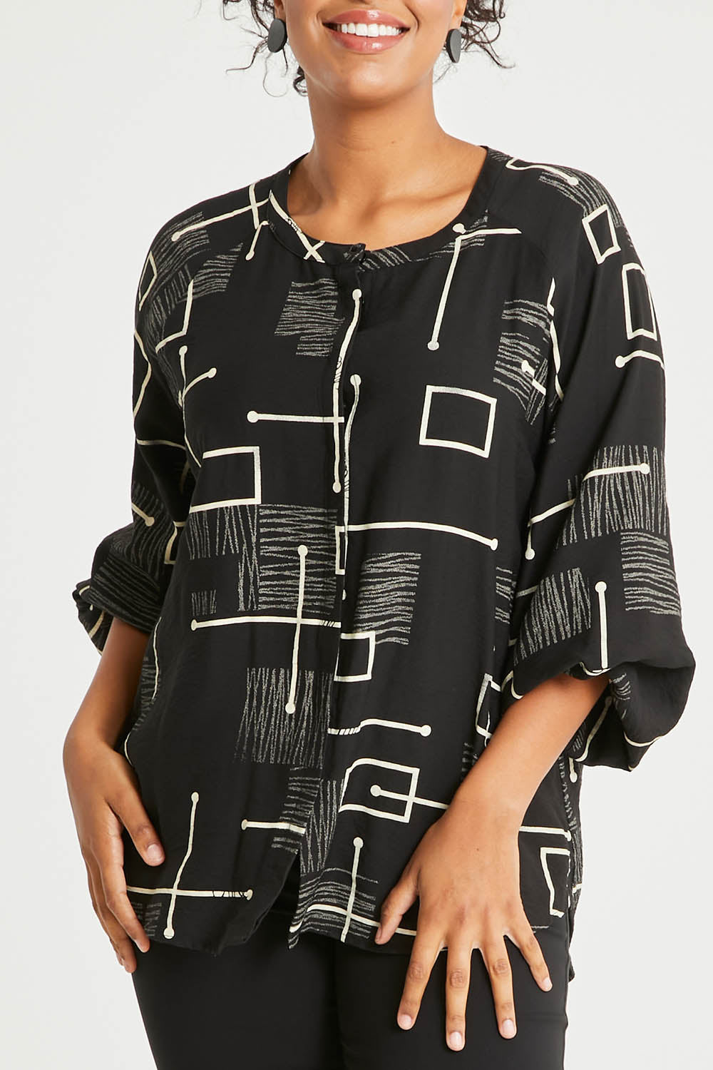 Model Noli wearing size 14 of The Keepers Printed Crew Neck Shirt in colour Blackivory (Black), from the front, cropped image