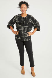 Model Noli wearing size 14 of The Keepers Printed Crew Neck Shirt in colour Blackivory (Black), from the front, showing the whole outfit