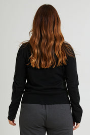 Model Laura wearing size L of The Keepers Soft Roll Neck Jumper in colour Black (Black), from the back