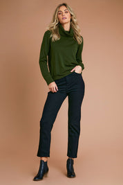 Model Alice wearing size S of The Keepers Soft Roll Neck Jumper in colour Darkolive (Green), from the front, showing the whole outfit